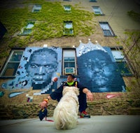 a man and a dog sitting in front of a building